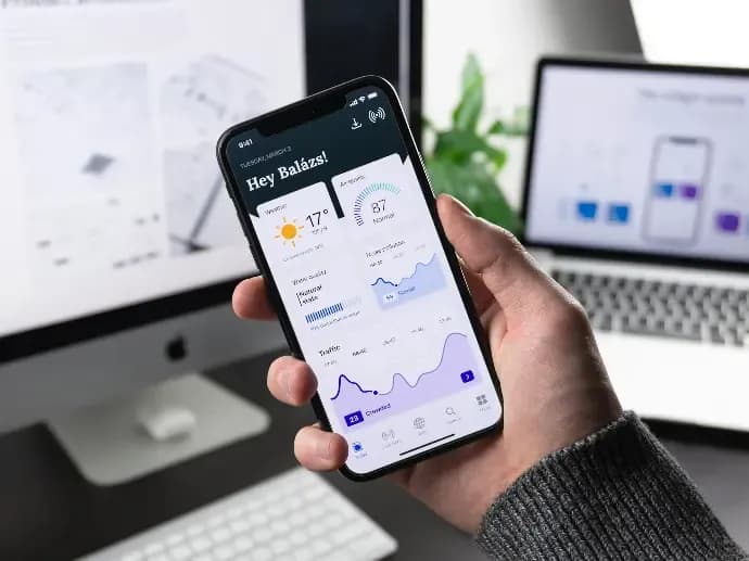 Người dùng cầm điện thoại xem dashboard ứng dụng mobile