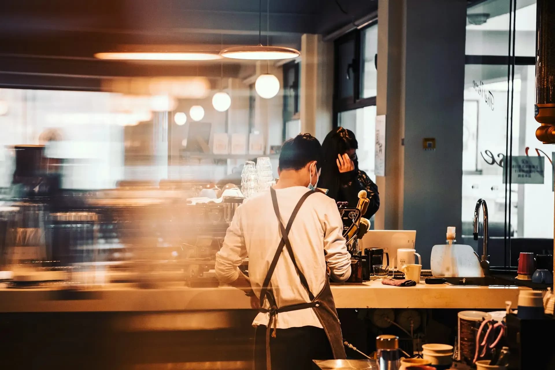 Barista working behind the counter of a coffee shop